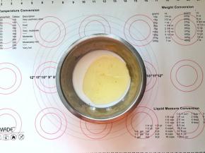 9、接下来制作冰皮，牛奶、糖粉、玉米油倒入盆中搅拌均匀。