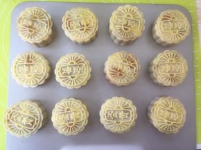 烤箱取出月饼，用毛刷粘一点点蛋黄液，毛刷在碗的边缘刮一下，留有少部分蛋黄液即可，之后在月饼表面刷上一层薄薄的蛋黄液；

