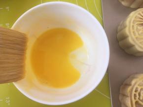 将月饼入烤箱烘烤5分钟，蛋黄加一点点水打散；
