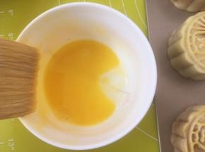 将月饼入烤箱烘烤5分钟，蛋黄加一点点水打散；
