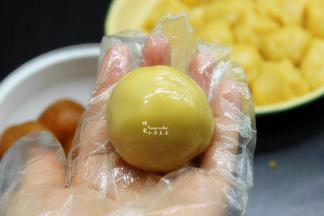 然后放入莲蓉蛋黄馅，包裹，揉成光滑圆团。