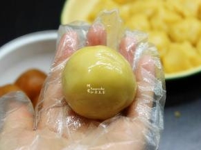 然后放入莲蓉蛋黄馅，包裹，揉成光滑圆团。