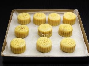 烤盘垫上硅油纸，把做好的月饼胚放入烤盘，然后喷上一些水，可以防月饼裂开。