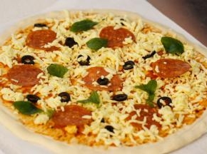 在饼皮上先抹一层披萨酱，放少量芝士后铺上萨拉米肠，黑橄榄片，表面再放少量的芝士和浸泡好的薄荷叶。