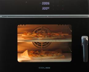 COUSS CO-960S电烤箱，300度预热完成，将2个披萨面团用面包铲分别移到石板上，烘烤约6分钟。