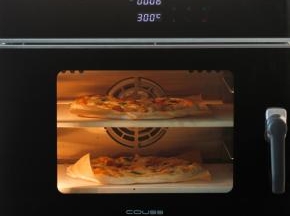 COUSS CO-960S电烤箱，300度预热完成，将2个披萨面团用面包铲分别移到石板上，烘烤约6分钟。