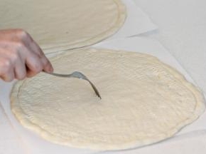 面团移到油纸上整理好，用叉子扎些孔。