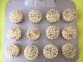 将包好的月饼装入模具内，压成形状，月饼全部做好后，在表层喷上一点水，静至10分钟，烤箱预热190度；
