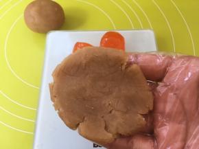 用手掌将莲蓉馅压扁；