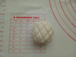 取适量白色面团做造型，捏成正方体，上面用刮板压一些纹路