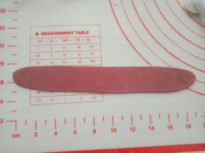 揉出适量红色面团，擀成长薄片