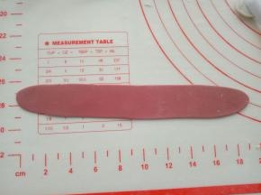 揉出适量红色面团，擀成长薄片