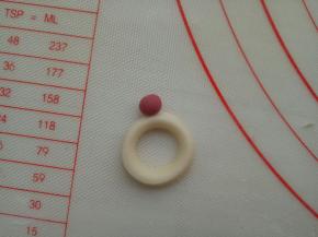 适量红色面团揉一个小圆，粘到指环上面