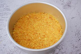 把融化的黄油倒入饼干中，拌匀，把拌匀的饼干放入八寸模具中压实，放入冰箱冷藏备用