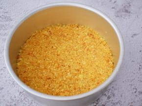 把融化的黄油倒入饼干中，拌匀，把拌匀的饼干放入八寸模具中压实，放入冰箱冷藏备用