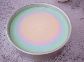 再把第二份彩色慕期从中间倒入，让它自然扩期，依次这次直至最后的彩色慕期糊倒完，放入冰箱冷藏4-6小时定型