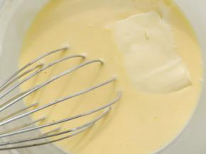 把加热的液体慢慢倒进之前的鸡蛋面糊中，边倒边搅拌。然后放入一片芝士趁着还有余温把它搅拌融化。