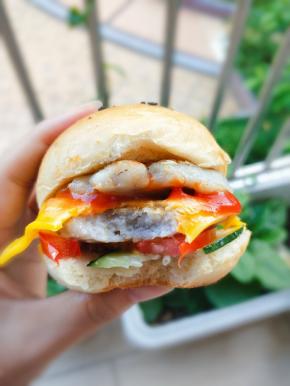 汉堡中间横切，切面抹上沙拉酱，夹上配菜、鱼饼和芝士