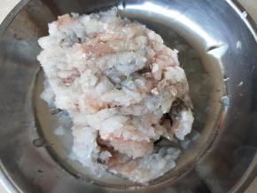 横剁了一遍的鱼蓉，倒入盐水拌匀
