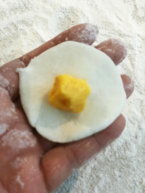 揪一块面团，捏薄，放入流心陷，包起来。