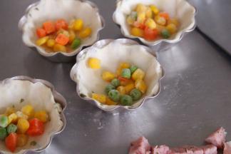 然后将飞饼皮覆盖在模具上，放入什锦菜