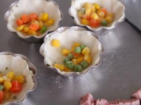 然后将飞饼皮覆盖在模具上，放入什锦菜