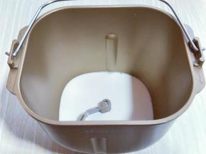 首先将纯牛奶倒入面包桶中。