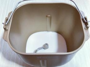 首先将纯牛奶倒入面包桶中。