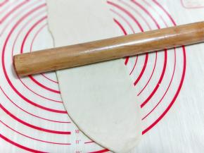 取一块小面团，用擀面杖擀长舌状。