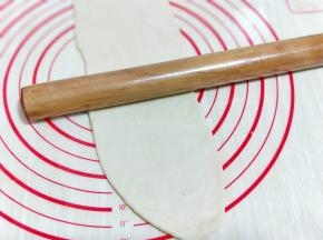 取一块小面团，用擀面杖擀长舌状。