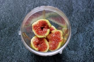 无花果去皮后，用刀切成两半后放入料理机的杯子里。