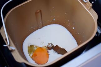 然后在面包桶的一角打入一个鸡蛋