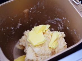 在面包机启动后，搅拌1完成后，面团成团停止休息时，这个时候加入黄油