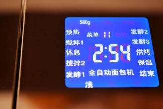 准备好后，把面包桶放入面包机中，旋转固定好，盖上面包机的盖子，选择菜单11，牛奶吐司面包，重量选择500克，烤色选择为浅，然后启动程序