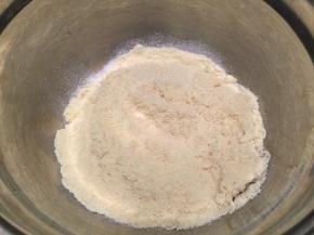 将过筛的糖粉和杏仁粉倒在蛋清上，盖住后包上鲜膜备用