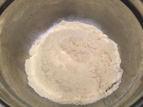 将过筛的糖粉和杏仁粉倒在蛋清上，盖住后包上鲜膜备用