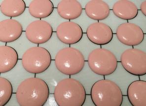 垂直拿起裱花袋，均匀地挤在马卡龙硅胶垫上，轻拍几下去气泡，空调房内（夏天）晾至表皮不沾手，有表壳