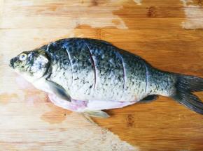 鲫鱼刮去鱼鳞，去掉鱼肠清洗干净，表面划切数刀