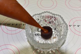 豆沙馅挖一个小孔，挤入5克流心馅，收口后搓圆