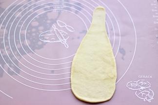 擀成长条形状后，再竖向擀成长长的三角形，如图。