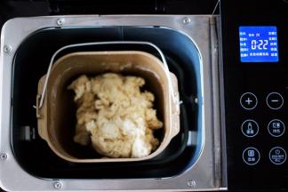 面包桶放入面包机，启动面包机自动揉面23分钟后。