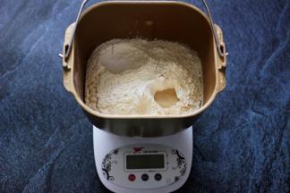 所有的食材称重备用，除黄油外的食材，全部加入面包桶中，先液体在粉类的顺序放入，最后在上面放入酵母粉，用面粉将酵母粉盖起来。