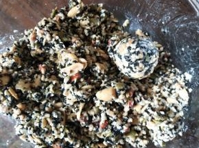 敲碎的果仁加入熟糯米粉、熟面粉、玉米油拌匀，加入清水，一点一点加，果仁能成团就不需要再加了。将五仁馅分成40克一个，饼皮25克一个