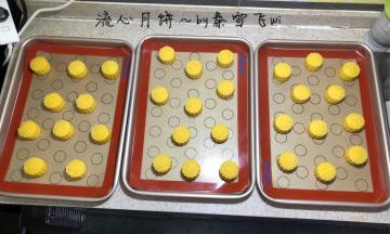 月饼馅包裹流心，都做好后把馅球再冷冻20分钟左右，然后再用月饼皮包好，压好模，压膜前在月饼皮表面轻轻滚一圈面粉，一点点就够，这样压膜不会掉皮，压好模的月饼再次入冰箱冷冻一个半小时