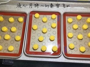 月饼馅包裹流心，都做好后把馅球再冷冻20分钟左右，然后再用月饼皮包好，压好模，压膜前在月饼皮表面轻轻滚一圈面粉，一点点就够，这样压膜不会掉皮，压好模的月饼再次入冰箱冷冻一个半小时