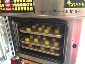 冰箱取出月饼后，表面喷些水，避免开裂，我用的是风炉，170度提前预热，烘烤3分钟后，取出刷蛋液，不要刷太多，花纹容易糊掉