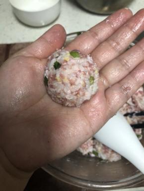 用勺子和手反复摔打一个，制成圆形