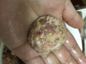 用勺子摔倒另一只手掌中，反复摔打成圆