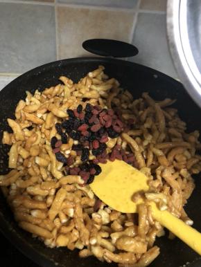 面条搅拌均匀的裹上糖浆，再放入枸杞和葡萄干，均匀之后再撒上芝麻搅拌均匀