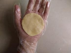 小面团在手掌上压扁，压成圆形